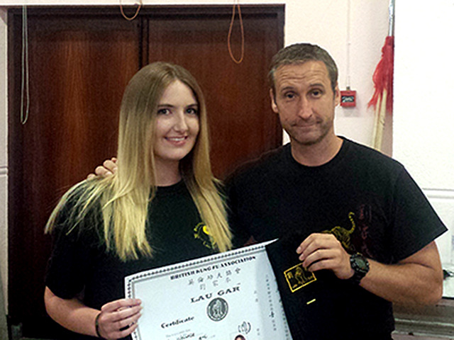 Laura receiving her Black Sash from Sifu Derek Dawson