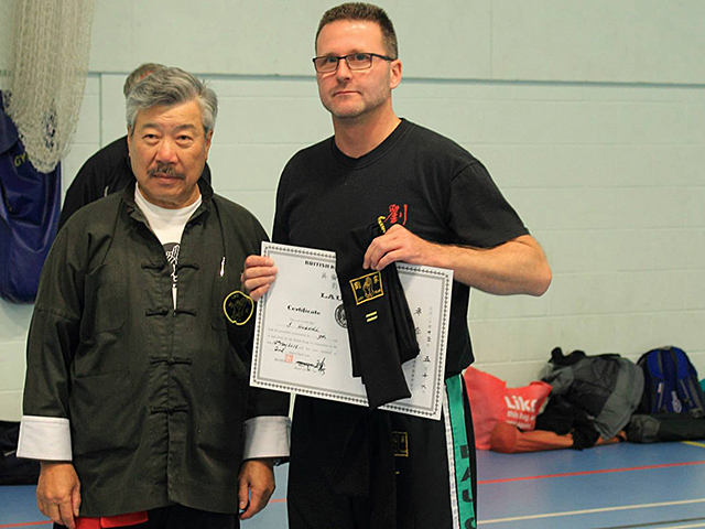 Simon Hugill receiving his Second Degree Black Sash from Master Yau at the BKFA Summer Course