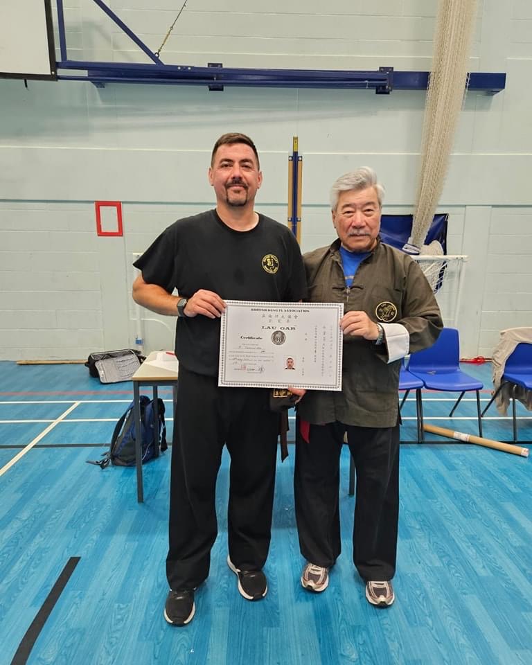 Paul Tunnicliffe receiving his Black Sash and Certificate from Grand Master Yau.